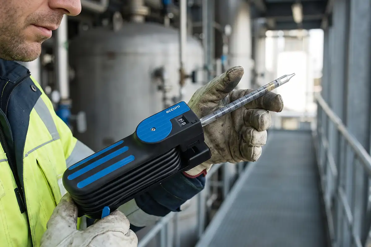 Cómo Elegir el Tubo Colorimétrico Correcto Según el Gas y el Rango de Medición 4 Bomba manual conectada a un tubo colorimétrico durante la toma de muestra